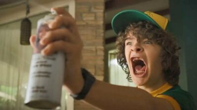 Dustin usando o Spray no rosto do Lucas em Stranges Things 3