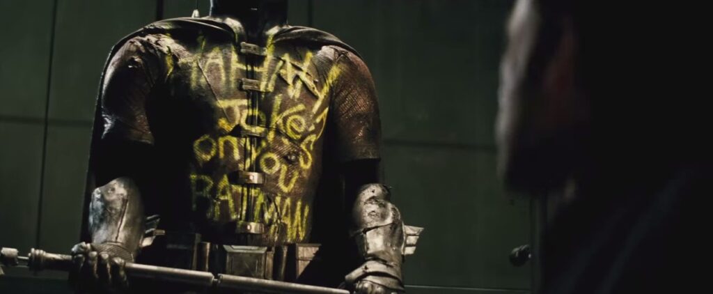 traje do Robin, de Jason Todd, com o escrito que "Agora a piada é você Batman"